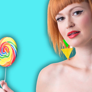 schöne junge Frau mit roten Haaren hält einen bunten Lollipop 